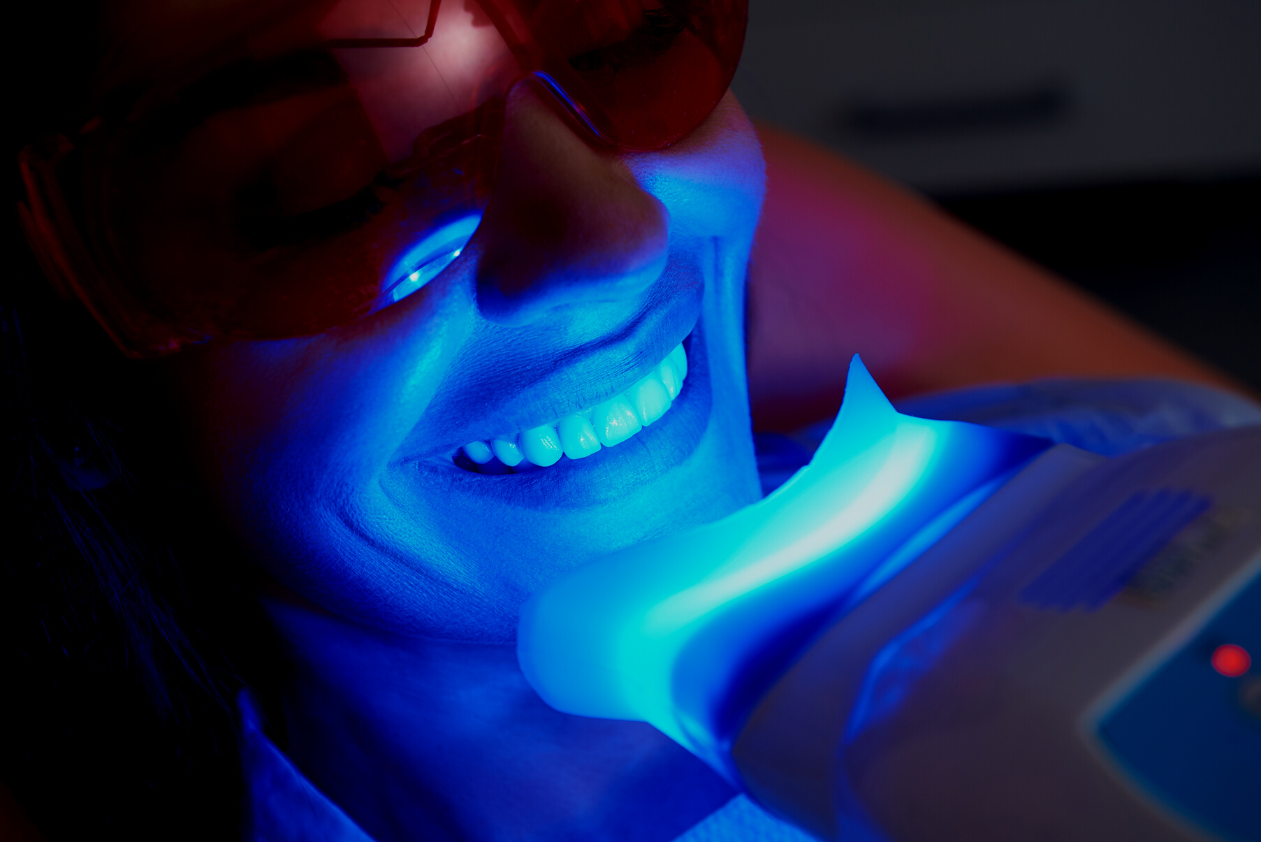 Adult woman is doing teeth whitening procedure